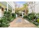 Inviting walkway leads up to a charming yellow house surrounded by lush landscaping at 25 Logan St, Charleston, SC 29401