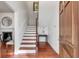 Welcoming entryway features hardwood floors, white stairs, and a stained-glass window at 25 Logan St, Charleston, SC 29401
