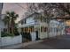 Charming two-story house with a yellow exterior, a white porch, and a wrought iron gate at 25 Logan St, Charleston, SC 29401
