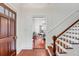 Bright foyer with dark wood door and staircase at 25 Logan St, Charleston, SC 29401