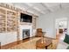 Inviting living room with brick fireplace, coffered ceiling and built-in shelving at 25 Logan St, Charleston, SC 29401
