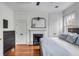 Bright main bedroom with decorative fireplace, hardwood floors, and white trim at 25 Logan St, Charleston, SC 29401