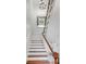 Bright staircase with wood and white finishes featuring a stained glass window at 25 Logan St, Charleston, SC 29401
