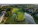 Aerial view of a golf course with a pond and luxurious homes at 27 Ocean Point Dr, Isle of Palms, SC 29451
