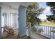 Relaxing covered balcony with wood flooring and furniture overlooking the scenic waterfront at 27 Ocean Point Dr, Isle of Palms, SC 29451