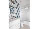 Charming bathroom featuring patterned wallpaper and a traditional white tub and vanity at 27 Ocean Point Dr, Isle of Palms, SC 29451