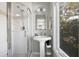 Well-lit bathroom with a pedestal sink, glass-enclosed shower, and a sunny window at 27 Ocean Point Dr, Isle of Palms, SC 29451
