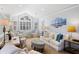 Bright and airy living room featuring a vaulted ceiling, large windows, and stylish furnishings at 27 Ocean Point Dr, Isle of Palms, SC 29451