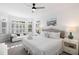 Bright main bedroom featuring a king bed, bay window, sitting area, and coastal decor at 27 Ocean Point Dr, Isle of Palms, SC 29451