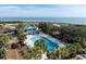 Resort-style pool with ocean views and a covered pavilion, surrounded by lush palm trees and lounge chairs at 27 Ocean Point Dr, Isle of Palms, SC 29451