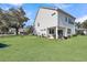 Rear view of the house and backyard, featuring a green lawn and shady trees at 3213 Great Egret Dr, Johns Island, SC 29455