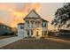 Two-story home boasts double porches, symmetrical design, and sunset sky at 3213 Great Egret Dr, Johns Island, SC 29455