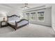 Serene main bedroom featuring a tray ceiling, a plush bed, and large windows for natural light at 3213 Great Egret Dr, Johns Island, SC 29455