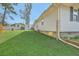 Large grassy backyard area showing the side exterior of home with trees and blue skies at 501 E Richardson Ave, Summerville, SC 29485