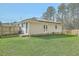 Spacious backyard with lush green grass, a wood fence, and the rear exterior view of the home at 501 E Richardson Ave, Summerville, SC 29485