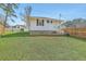 Backyard showing side view of the home with trees and blue skies on a grassy lawn at 501 E Richardson Ave, Summerville, SC 29485