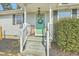 Welcoming front porch with a charming green door, decorative wreath, and a cozy chair at 501 E Richardson Ave, Summerville, SC 29485