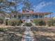 Charming two-story home with a red roof, brick pathway, covered porch, and landscaped front yard at 547 Island Walk, Mount Pleasant, SC 29464