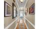 Well-lit hallway with hardwood floors, decorative trim, and a gallery of artwork along the walls at 547 Island Walk, Mount Pleasant, SC 29464