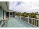 Outdoor balcony featuring turquoise flooring, white railings, and views of lush greenery and neighborhood homes at 6 4Th Ave, Isle of Palms, SC 29451