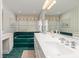 Unique bathroom showcasing a green tiled tub, double vanity, and ample mirror space for a luxurious experience at 6 4Th Ave, Isle of Palms, SC 29451