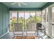 Screened porch with rocking chairs and beautiful views of the surrounding palm trees at 6 4Th Ave, Isle of Palms, SC 29451