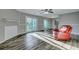 Bright living room featuring wood floors, a cozy red armchair, and sliding glass doors to the outside at 6275 Rolling Fork Rd # C, North Charleston, SC 29406