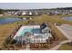 A beautiful aerial view of a community pool, poolhouse, playground and pond in a Gathering friendly neighborhood at 641 Sienna Way, Summerville, SC 29486