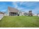 Wide shot of a large, green backyard featuring a patio and playground surrounded by a white picket fence at 641 Sienna Way, Summerville, SC 29486