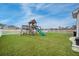 Backyard featuring a playground set with a green slide, swings, and a white fence surrounding the yard at 641 Sienna Way, Summerville, SC 29486
