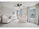 Bright Bedroom with a ceiling fan, white crib, dresser, glider, and two windows with stylish curtains at 641 Sienna Way, Summerville, SC 29486