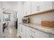 White butler's pantry with granite countertops, ample cabinet space, and stainless steel microwave at 641 Sienna Way, Summerville, SC 29486