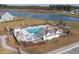 Aerial view of a community pool, clubhouse and poolhouse, with lounge seating near a scenic pond at 641 Sienna Way, Summerville, SC 29486