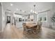 Bright dining room with a large wooden table next to an open, modern kitchen with stainless steel appliances at 641 Sienna Way, Summerville, SC 29486