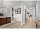 Elegant hallway featuring light wood floors, decorative wainscoting, crown moulding and a view into the living spaces at 641 Sienna Way, Summerville, SC 29486