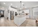 Spacious kitchen with white cabinets, a large granite island, stainless steel appliances, and light wood floors at 641 Sienna Way, Summerville, SC 29486
