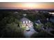 An aerial view of a home near the water during a lovely sunset, surrounded by trees at 7 Seahorse Ct, Isle of Palms, SC 29451