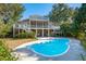 Backyard features a pool, mature trees, and green space, perfect for relaxation at 7 Seahorse Ct, Isle of Palms, SC 29451