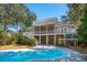 Backyard featuring a sparkling swimming pool, lush greenery, and home exterior at 7 Seahorse Ct, Isle of Palms, SC 29451