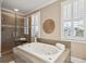 Bathroom with large tub, glass-enclosed shower, and plantation shutters provides relaxation and elegance at 7 Seahorse Ct, Isle of Palms, SC 29451