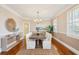 Sunlit dining room with hardwood floors, a table with seating for six, complemented by wainscoting and natural light at 7 Seahorse Ct, Isle of Palms, SC 29451