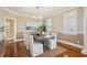 Charming dining room with hardwood floors, a modern chandelier, and ample natural light from the shuttered windows at 7 Seahorse Ct, Isle of Palms, SC 29451