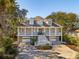 Stunning exterior elevation of a home featuring covered front porches, garages, and a circular driveway at 7 Seahorse Ct, Isle of Palms, SC 29451
