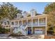 Lovely raised home featuring an inviting front porch, symmetrical design, and convenient garage access at 7 Seahorse Ct, Isle of Palms, SC 29451