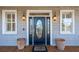Charming front entrance featuring a black door with decorative glass, flanked by sconces and potted plants at 7 Seahorse Ct, Isle of Palms, SC 29451