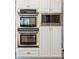 Stainless steel double oven and microwave are built into white cabinetry at 7 Seahorse Ct, Isle of Palms, SC 29451