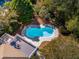 An aerial view of a private backyard featuring a kidney-shaped pool surrounded by trees and a deck at 7 Seahorse Ct, Isle of Palms, SC 29451
