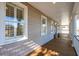 Covered porch featuring wood floors, decorative columns, and a view of the nearby house and landscaping at 7 Seahorse Ct, Isle of Palms, SC 29451