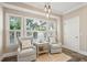 Cozy sitting area bathed in natural light from the large windows with two cushioned chairs at 7 Seahorse Ct, Isle of Palms, SC 29451