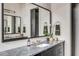 Bright bathroom featuring a large mirror, stylish vanity with black cabinets, and elegant countertop decor at 71 Wentworth St # 302, Charleston, SC 29401